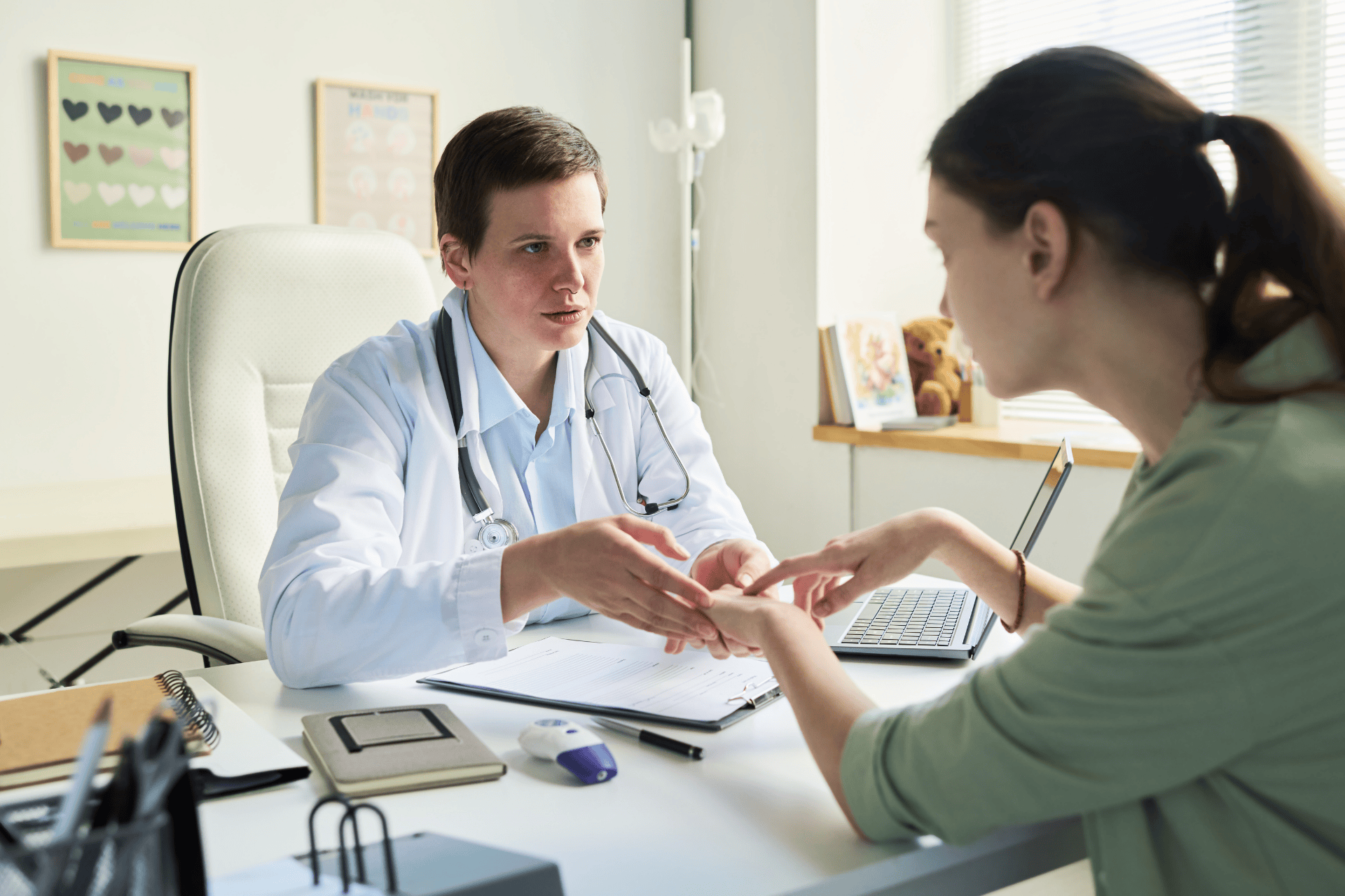 Doctor examining a patient’s hand during a medical consultation.