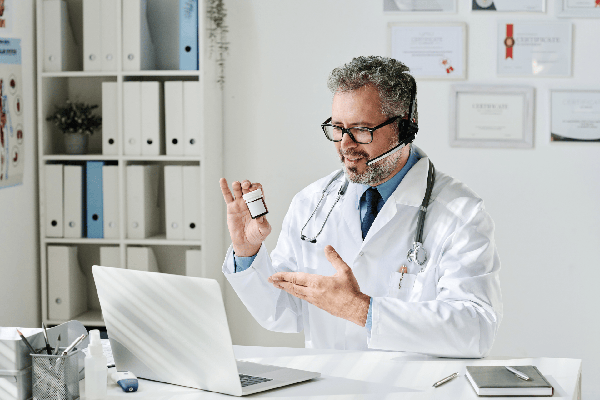 Doctor giving an online consultation while showing a small medicine bottle.
