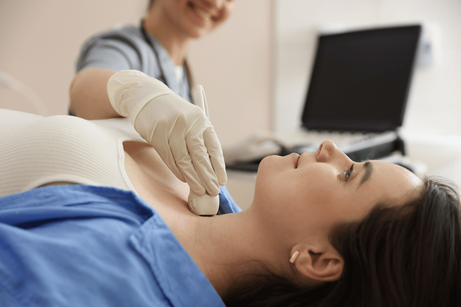 Medical professional performing an ultrasound scan on a patient’s neck.