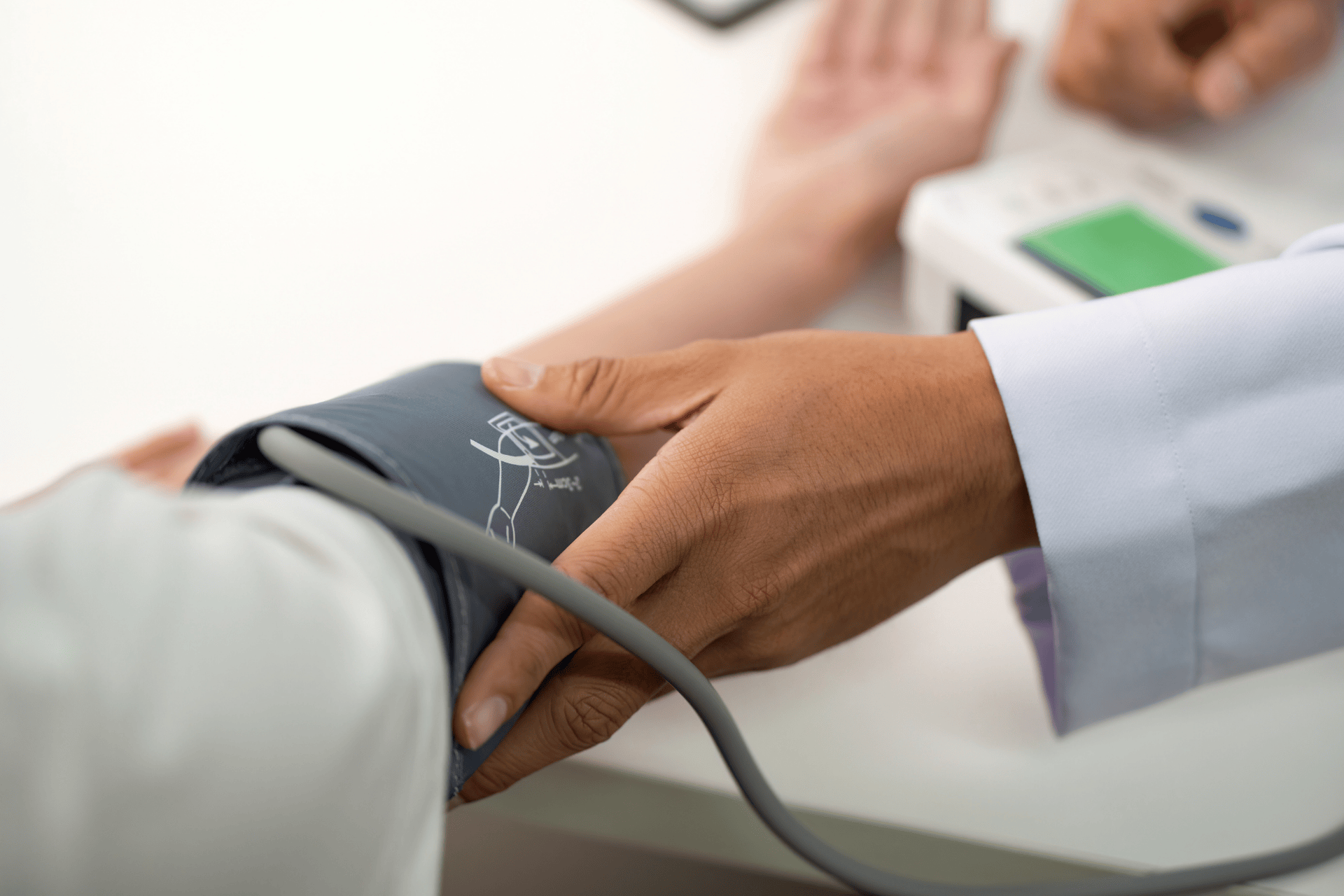 Doctor measuring a patient’s blood pressure with a cuff.