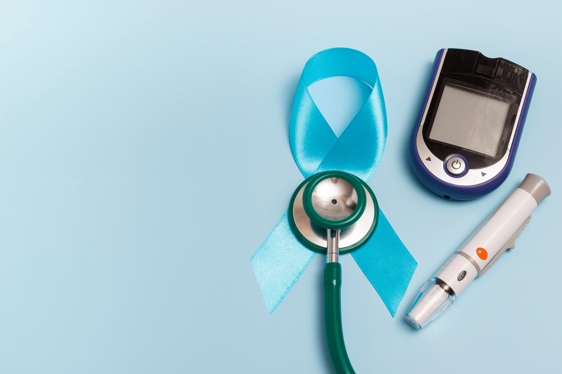Diabetes awareness ribbon with a stethoscope, glucose meter, and insulin pen on a blue background.