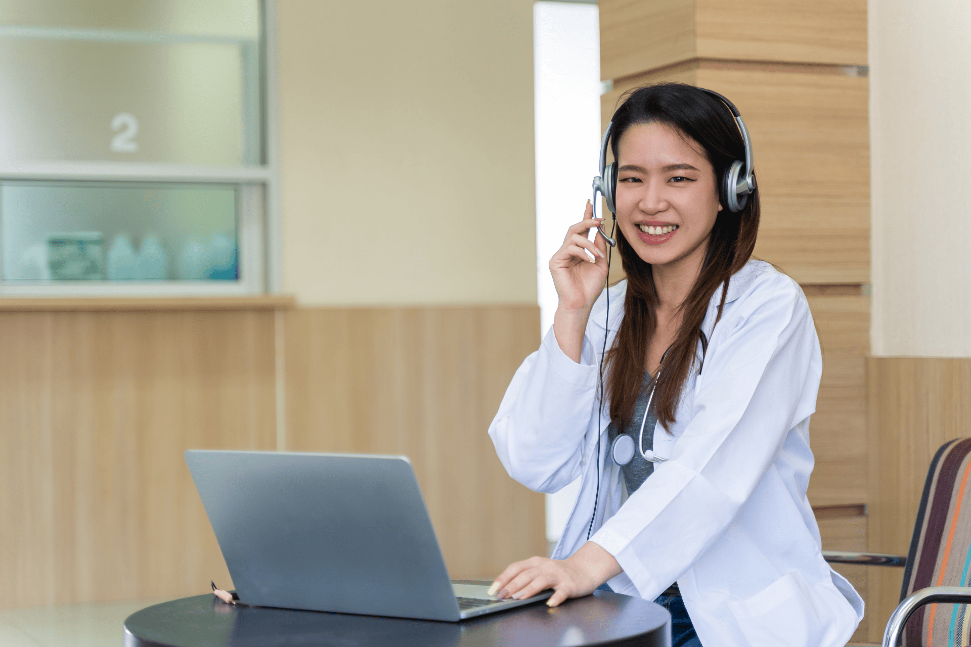 Doctor wearing a headset smiling during an online consultation.