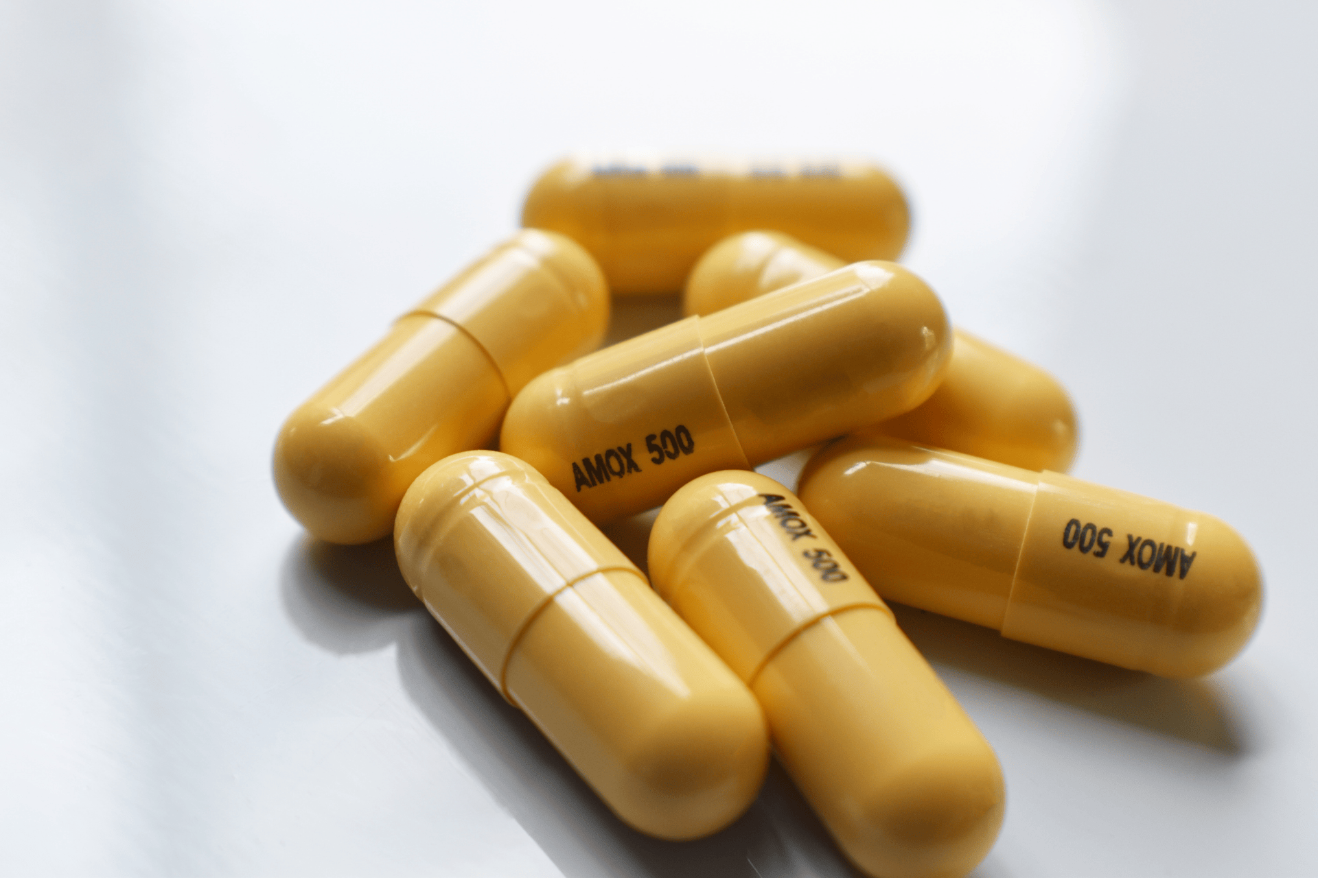 Close-up of yellow antibiotic capsules labeled AMOX 500
