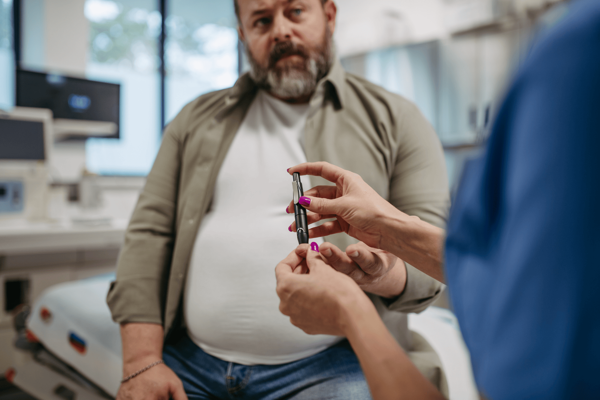 Healthcare provider showing an insulin pen to a patient during a clinic visit.