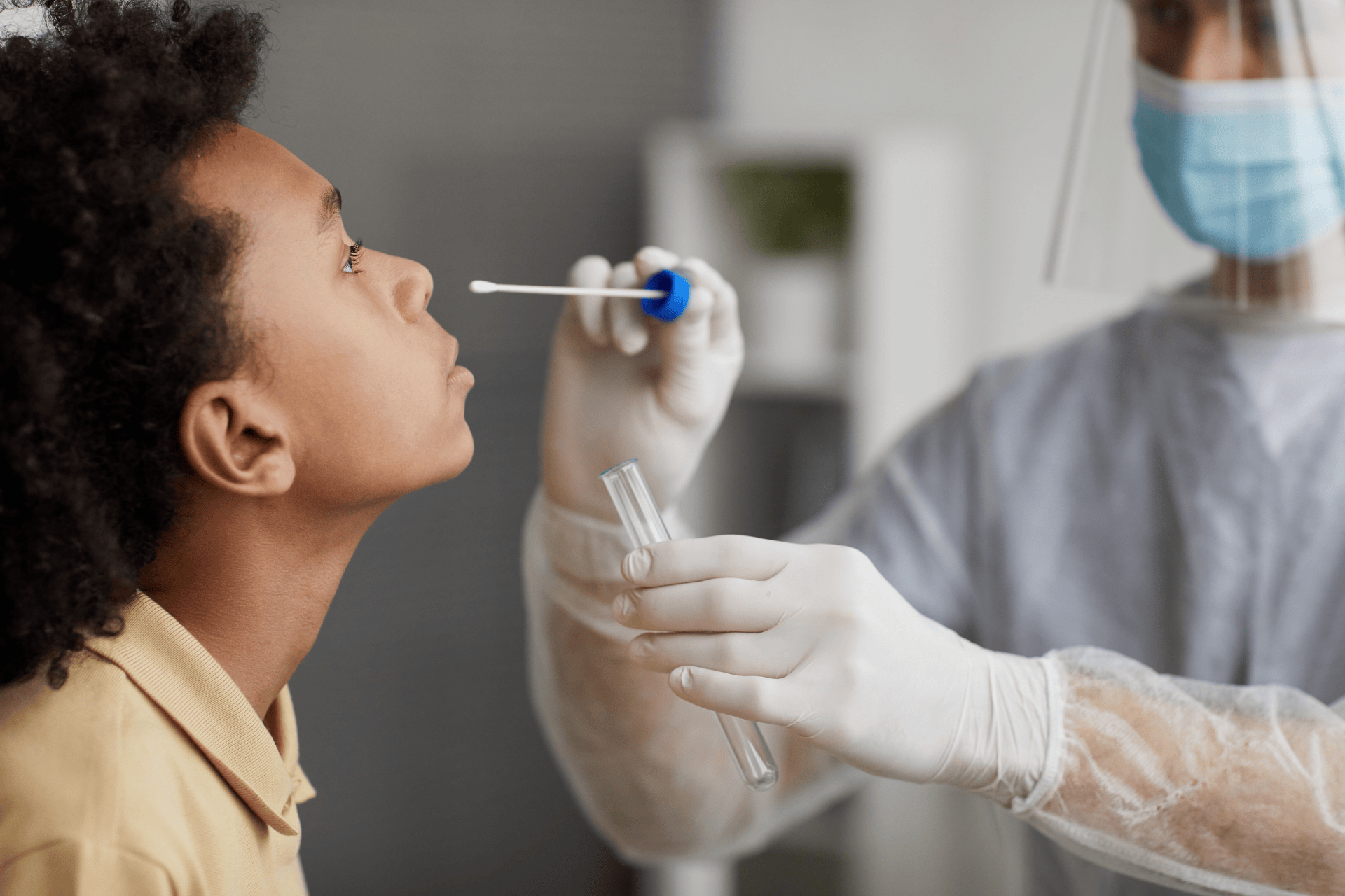 Healthcare worker performing a nasal swab flu test on a child.