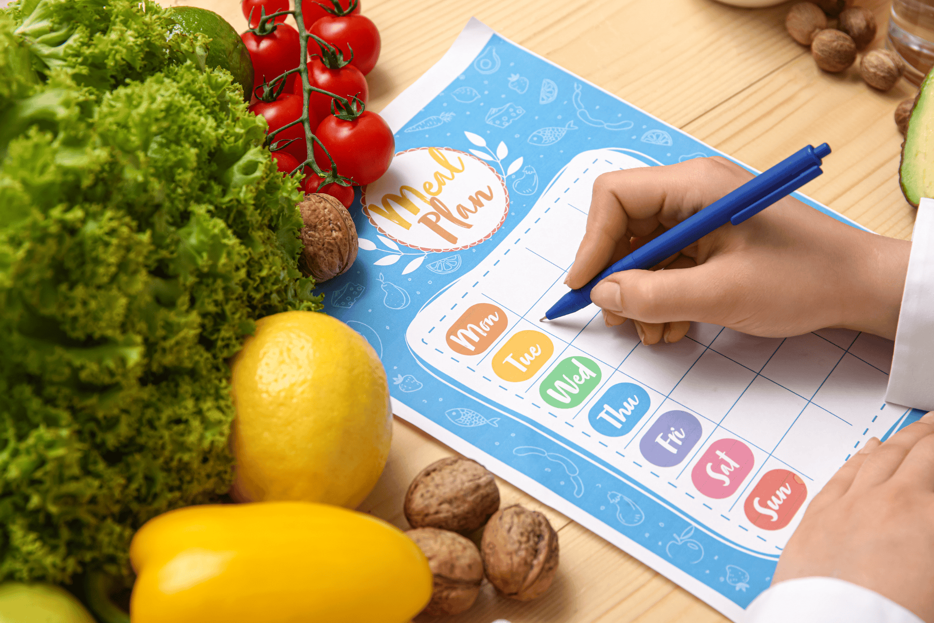Person writing a weekly meal plan next to fresh vegetables