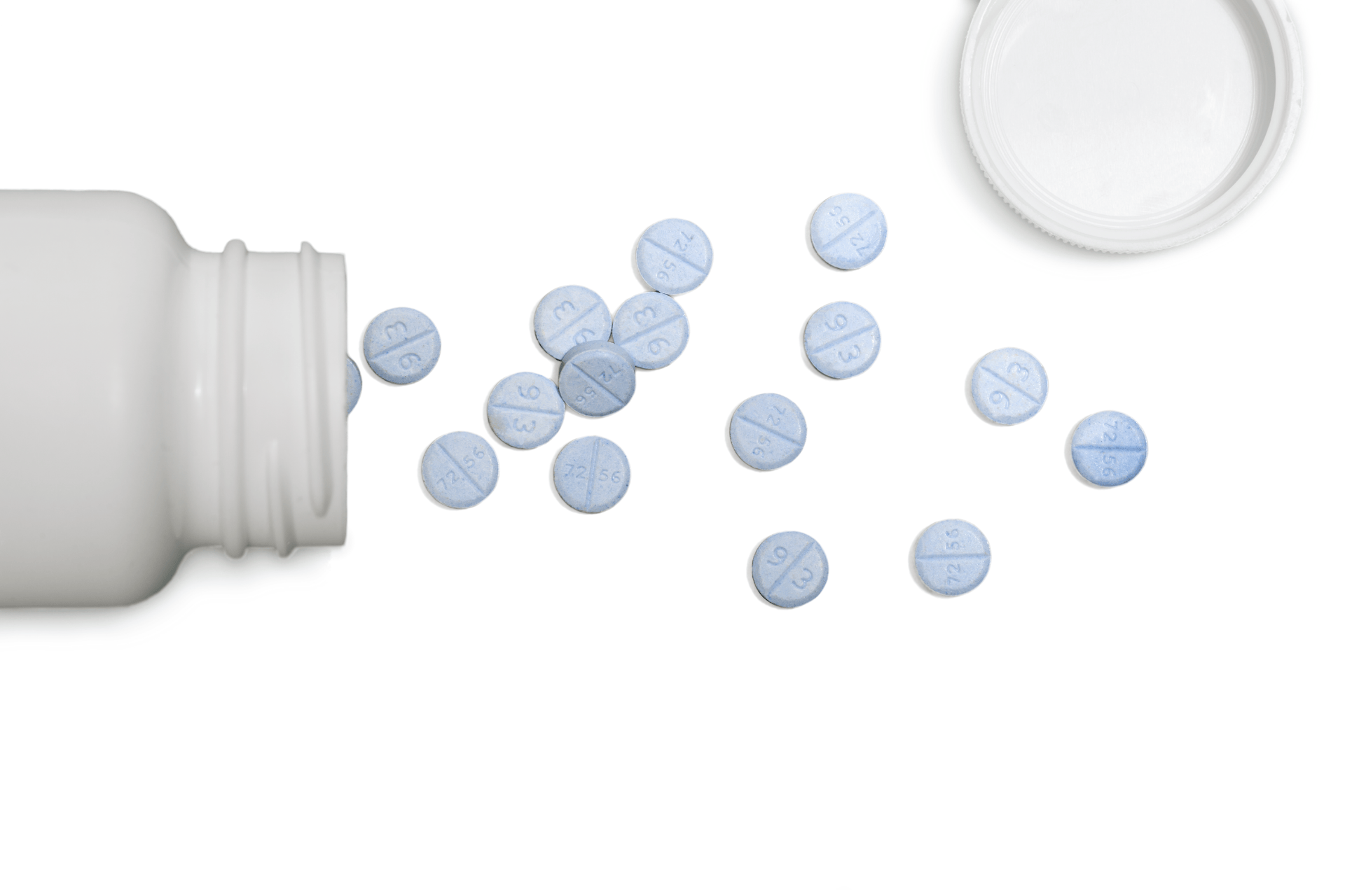 Blue tablets spilled from an open white pill bottle on a white background.