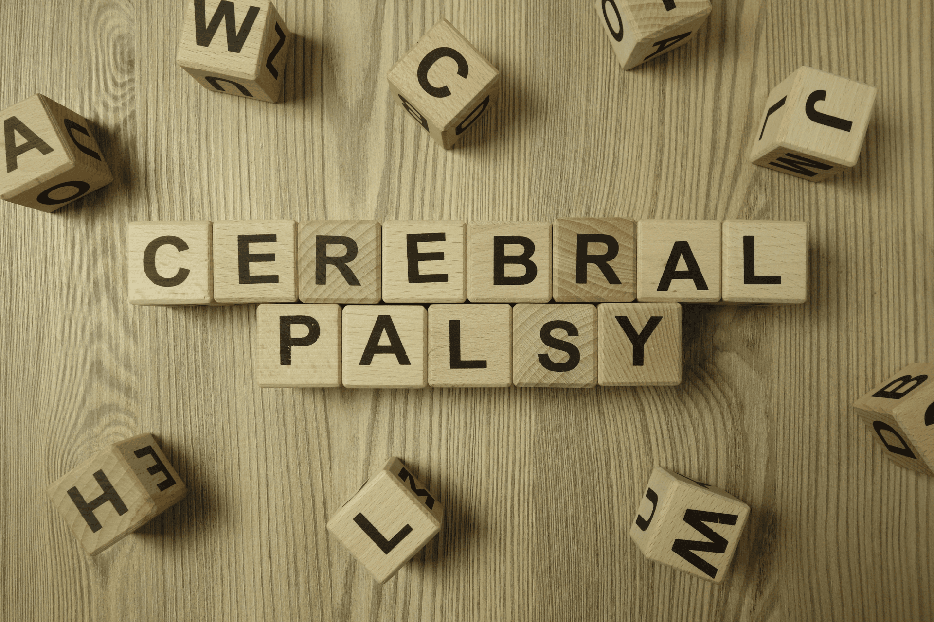 Wooden letter blocks spelling “cerebral palsy” on a table.