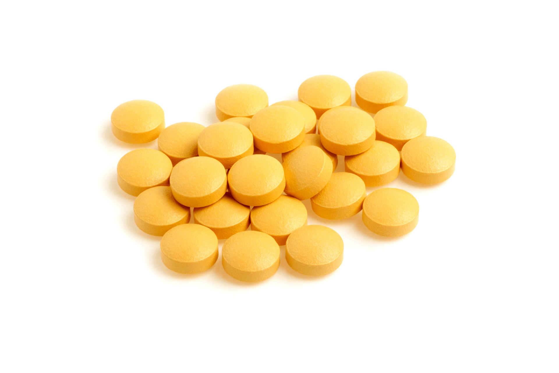 Pile of round yellow tablets on a white background.