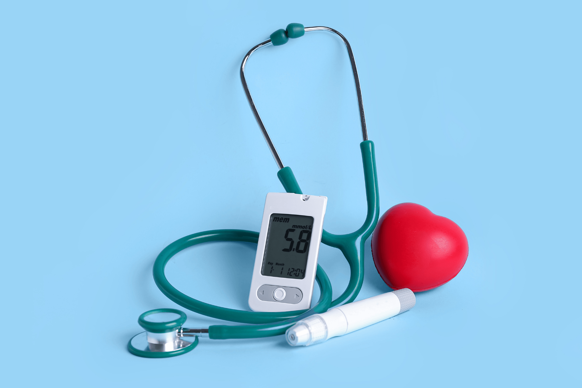 A blood glucose meter with a stethoscope, lancing device, and red heart on a light blue background.