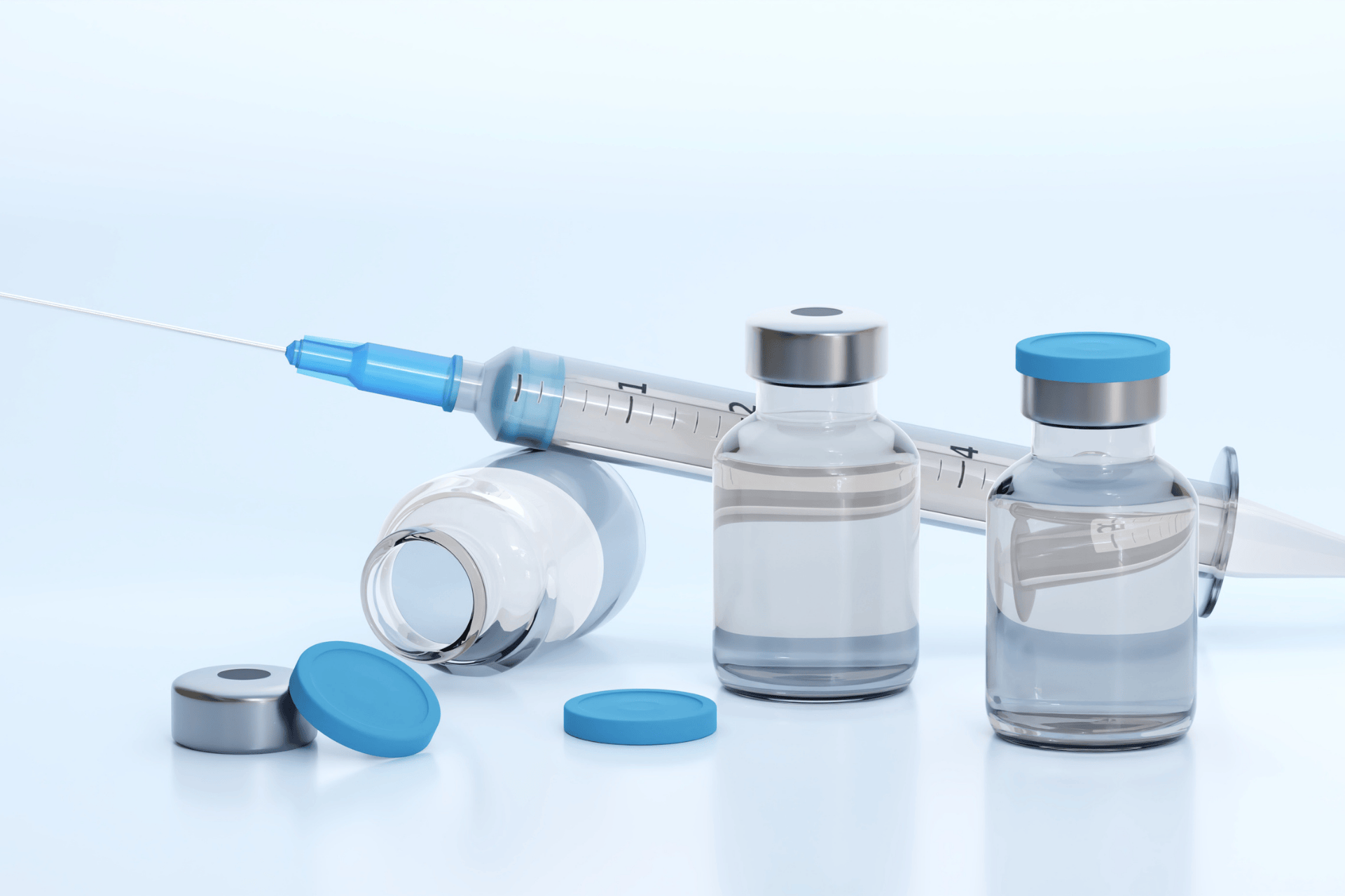 Insulin vials and a syringe arranged on a light blue background.