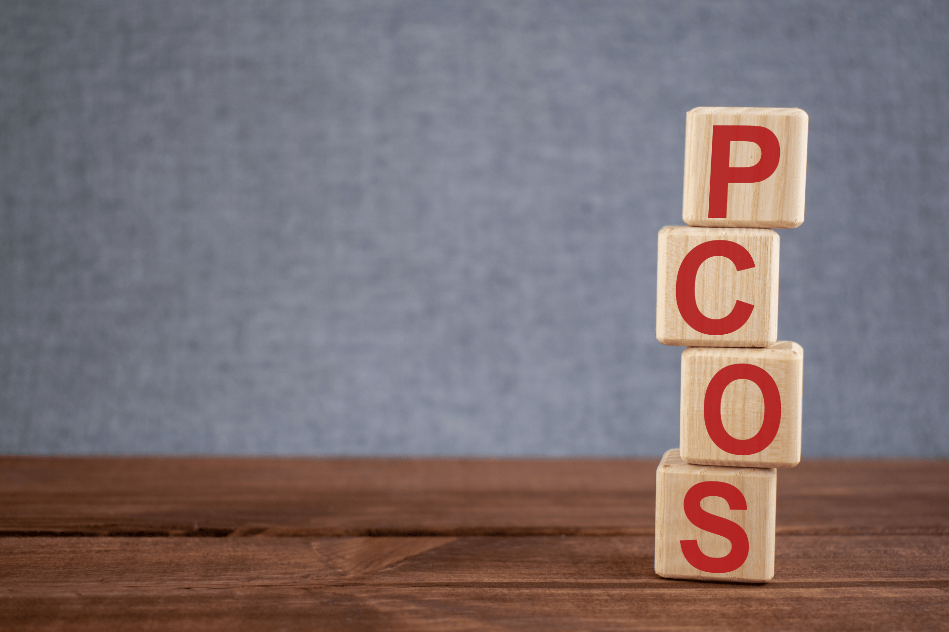 Wooden blocks spelling PCOS, representing polycystic ovary syndrome awareness and women’s health.