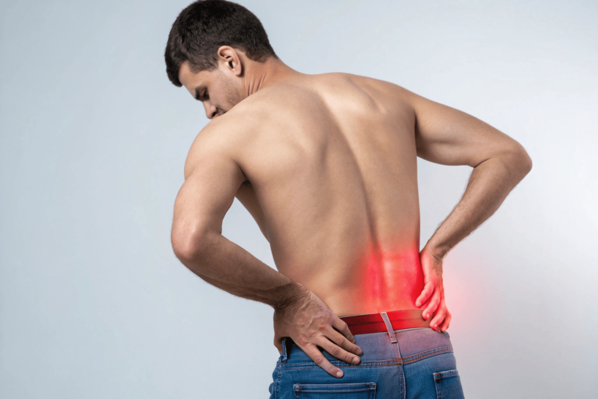 Man holding his lower back with a red highlight indicating body aches or back pain.