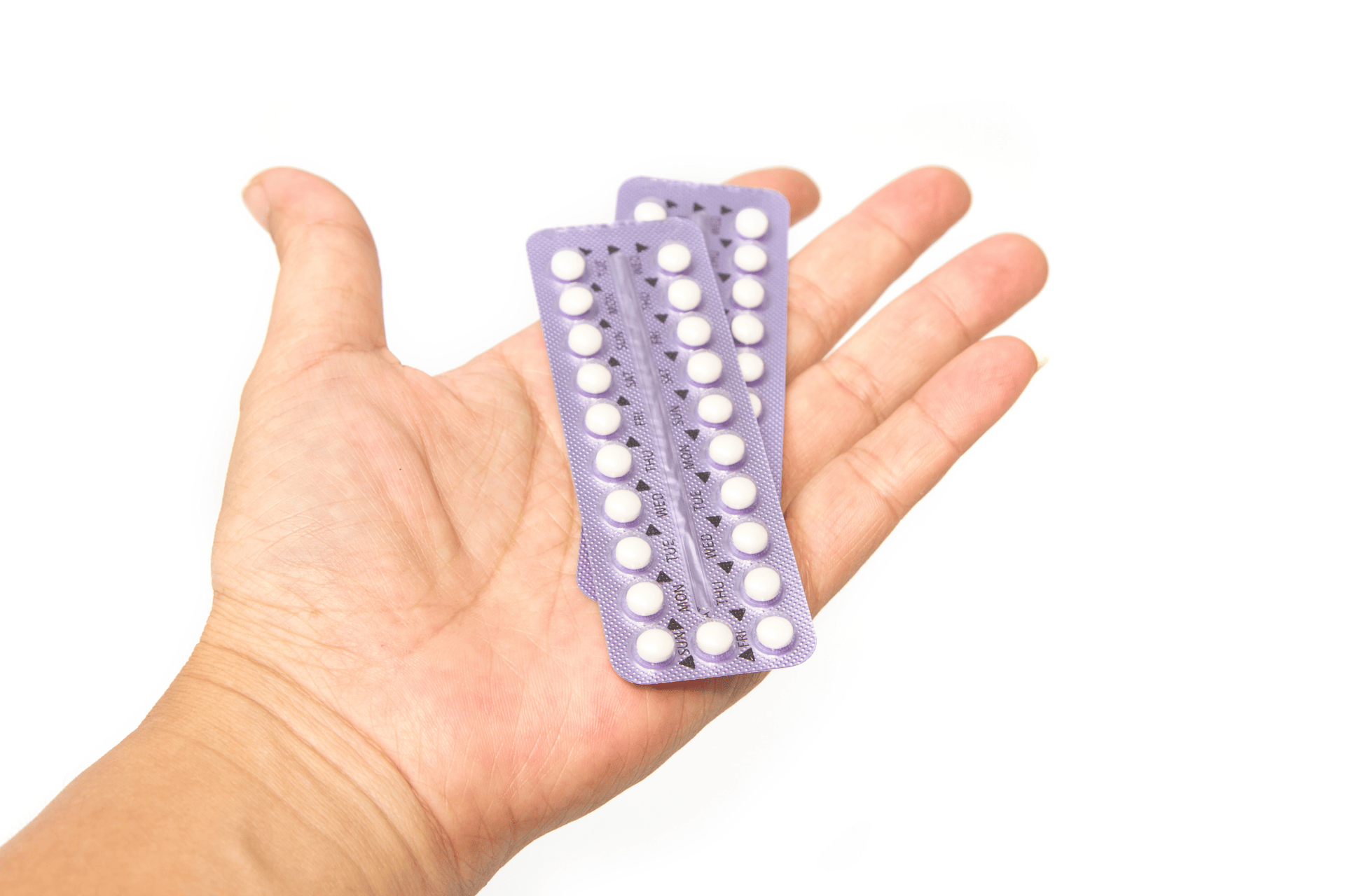 Hand holding two blister packs of birth control pills with purple backing.