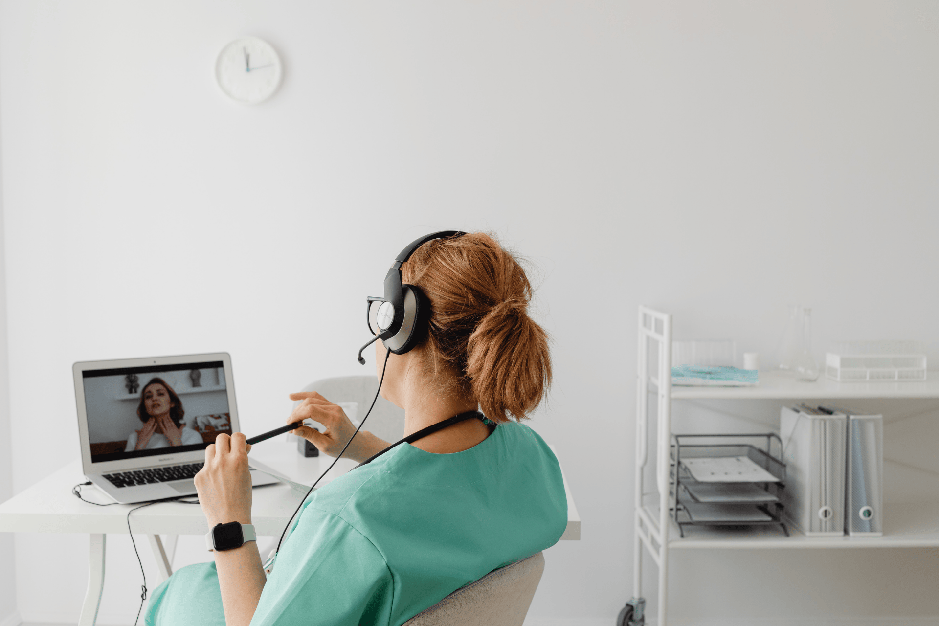 Nurse wearing a headset conducting an online video consultation with a patient.