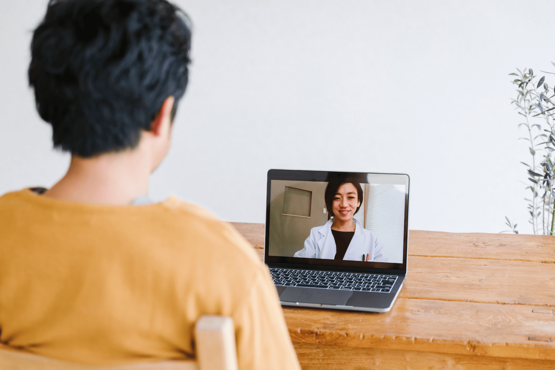 Patient having an online video consultation with a doctor on a laptop.