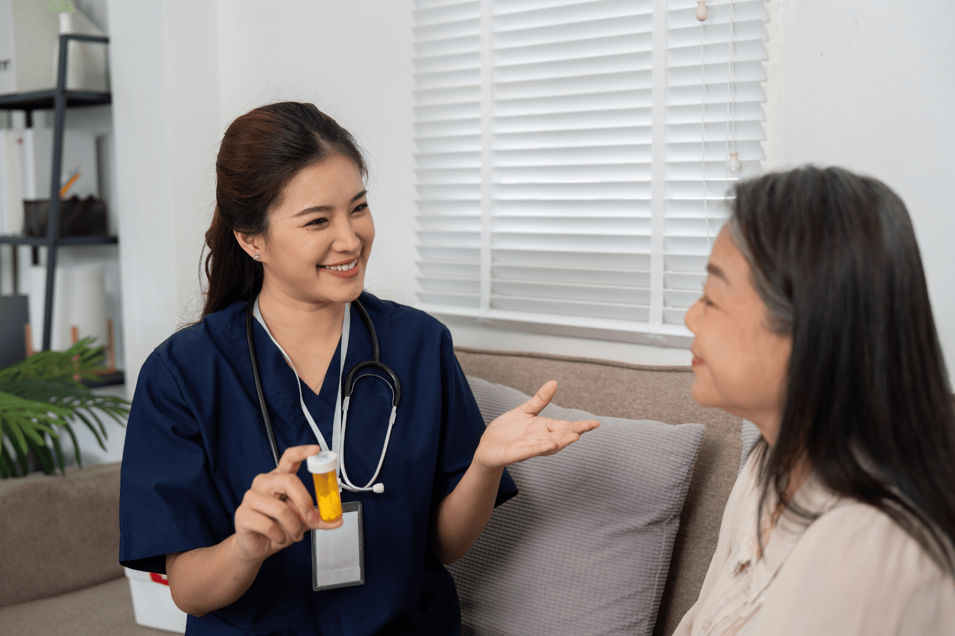 Nurse showing a prescription bottle to an older patient while smiling.