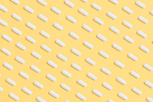 White capsules on yellow background.
