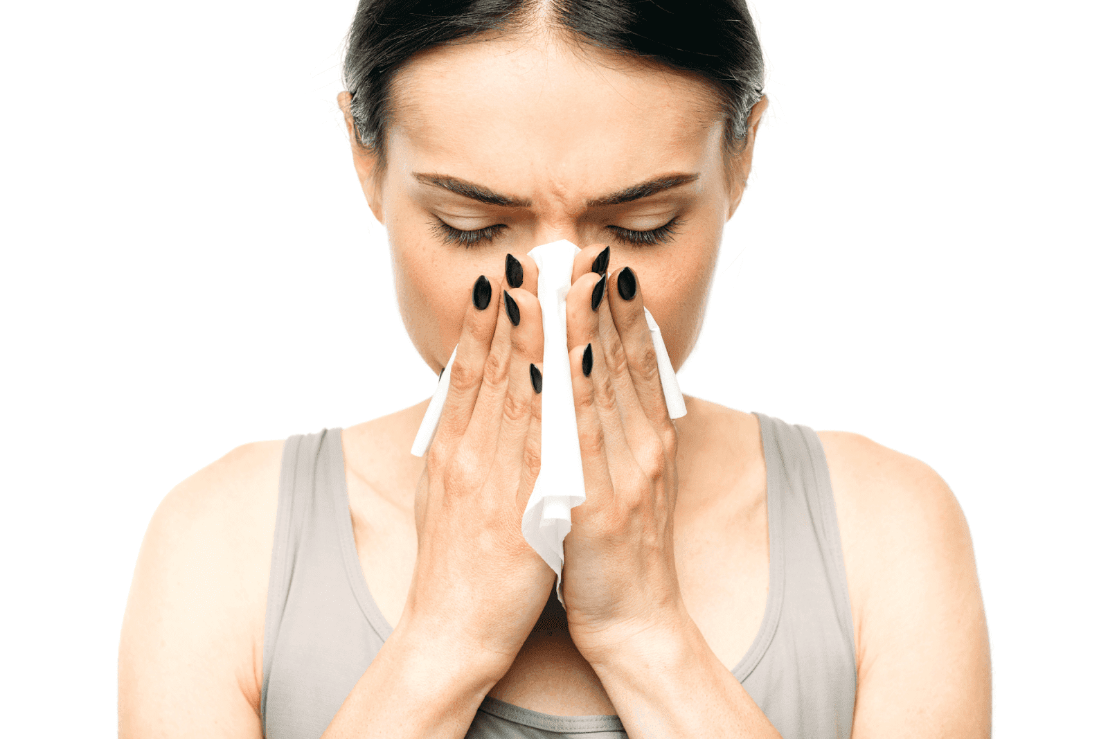 Woman blowing her nose in a tissue with eyes closed.