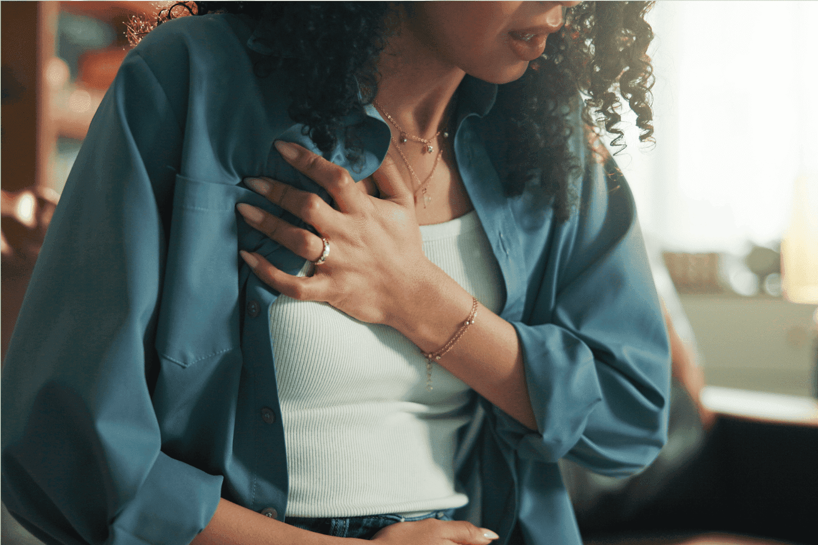 Woman clutching her chest in discomfort, suggesting chest pain.