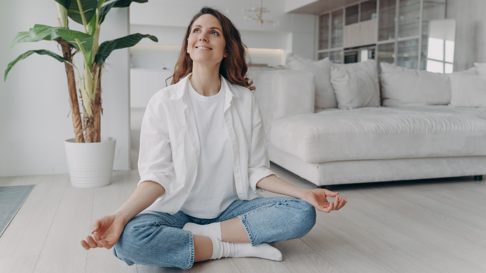 Woman sitting on floor meditating and smiling