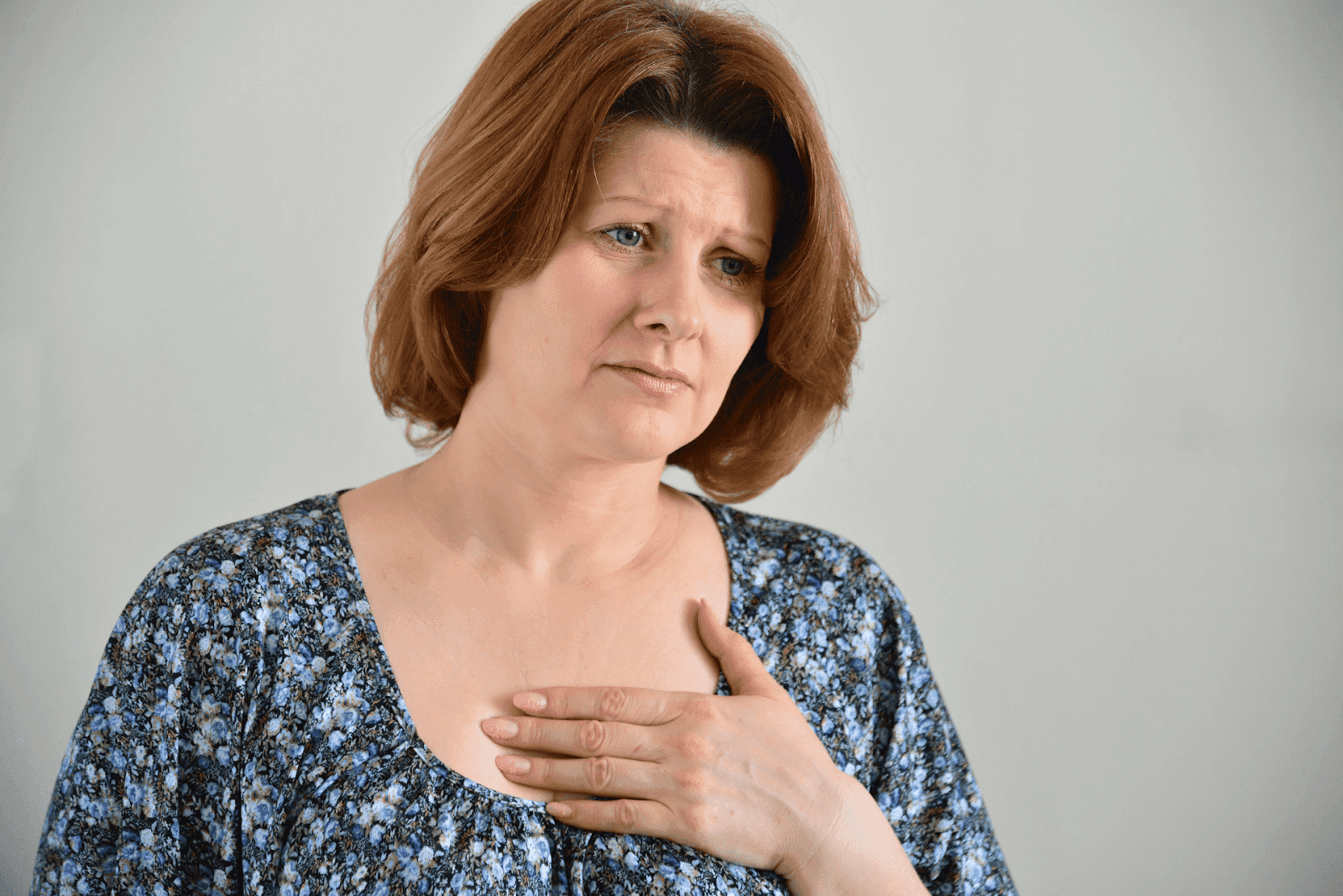 Woman holding her chest with a concerned expression