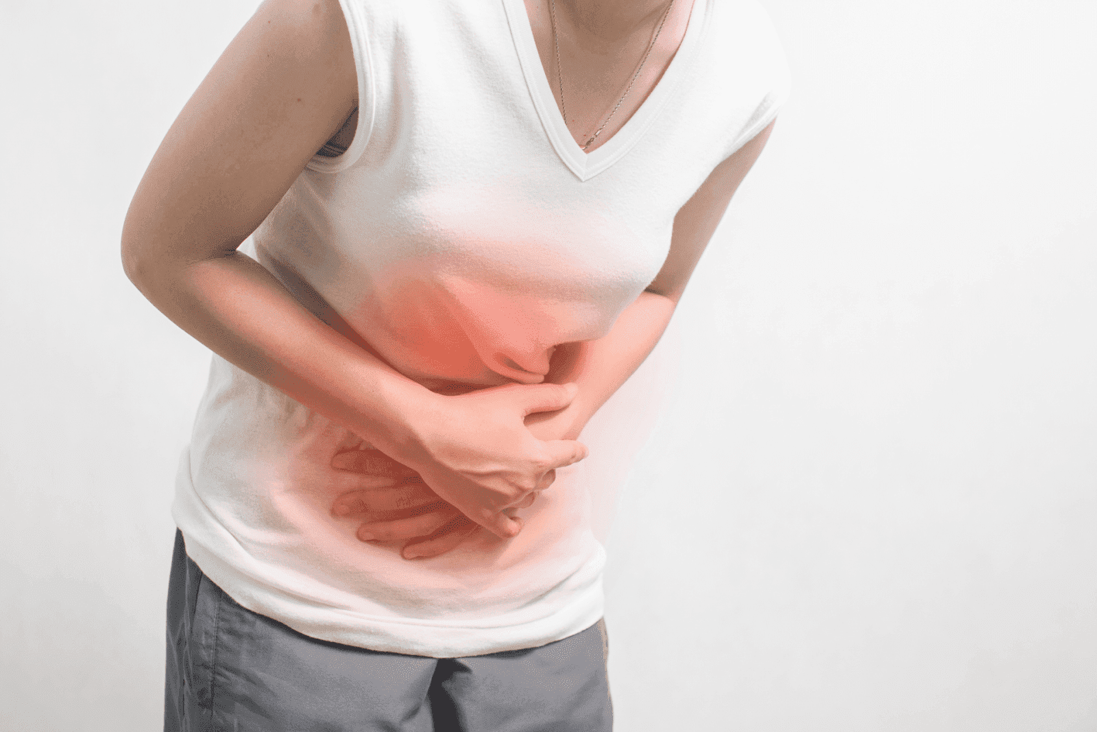 Woman holding her lower abdomen in pain with red highlight showing discomfort