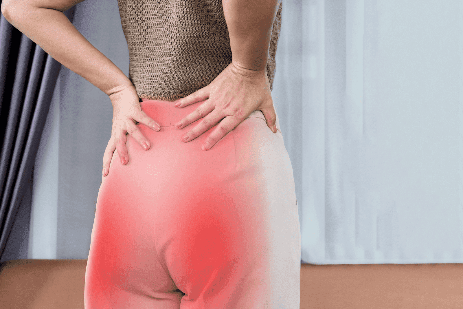 Woman holding her lower back in pain, highlighting hip and lumbar discomfort.
