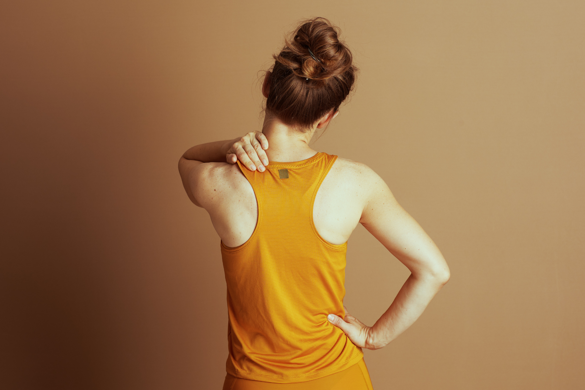 Woman holding her neck and lower back, showing upper and lower back pain