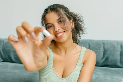 Woman holding a pill.