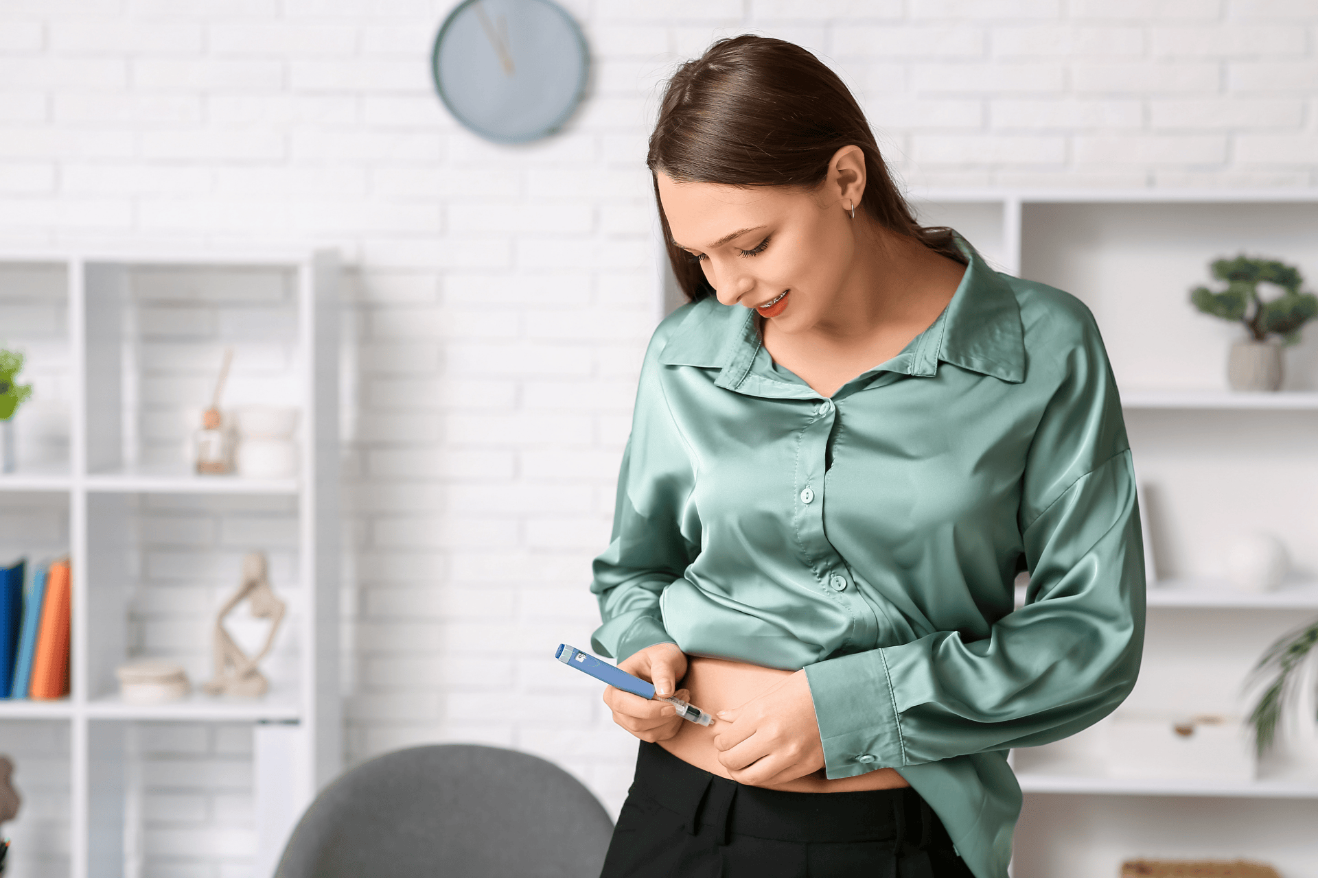 Woman injecting medication into her abdomen using a blue injection pen