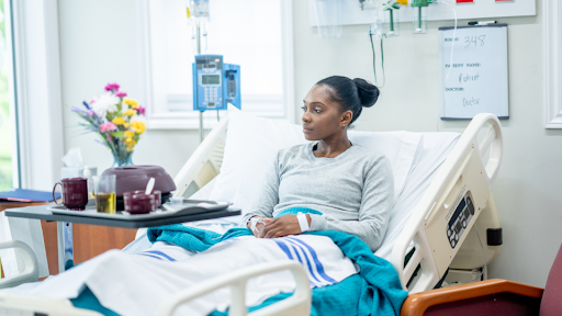 Woman sitting in hospital bed with tray of food in front of her