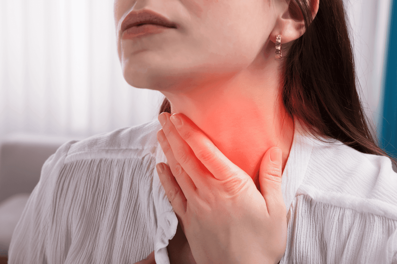 Woman touching her throat in pain with red highlight showing discomfort.
