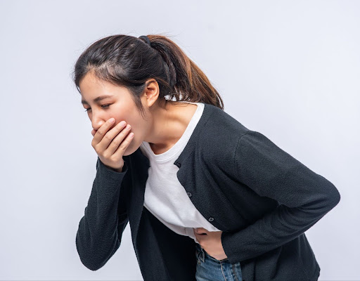 Woman covering her mouth because of vomit
